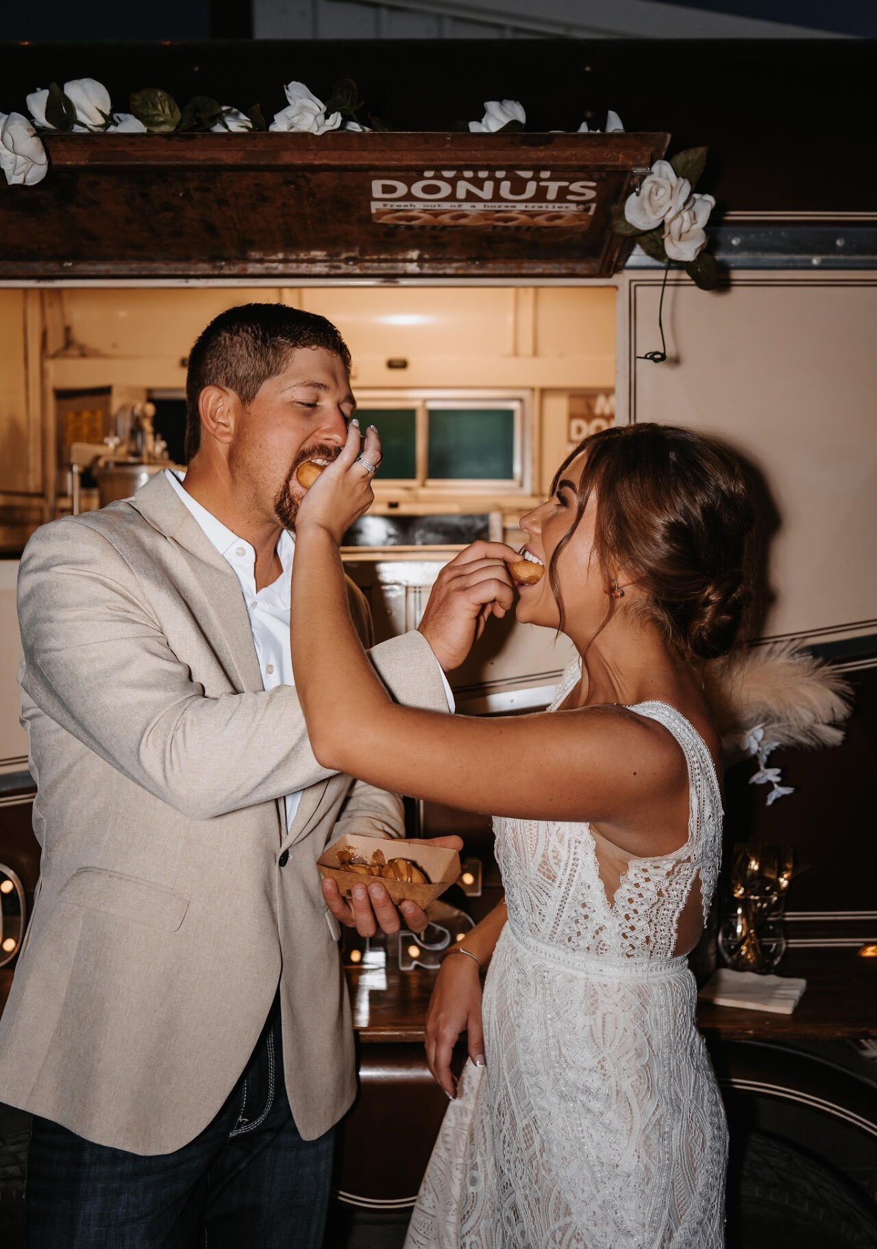 An engaged couple holding donuts